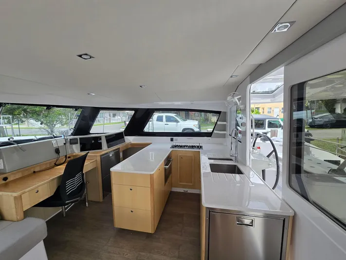  Yacht Photos Pics Modern interior of 2025 Seawind 1370 catamaran with sleek kitchen and work area.
