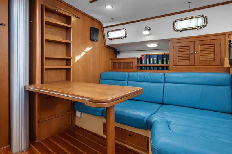 Mawe Yacht Photos Pics Interior of 2006 Island Packet 440 yacht with blue seating and wooden table.