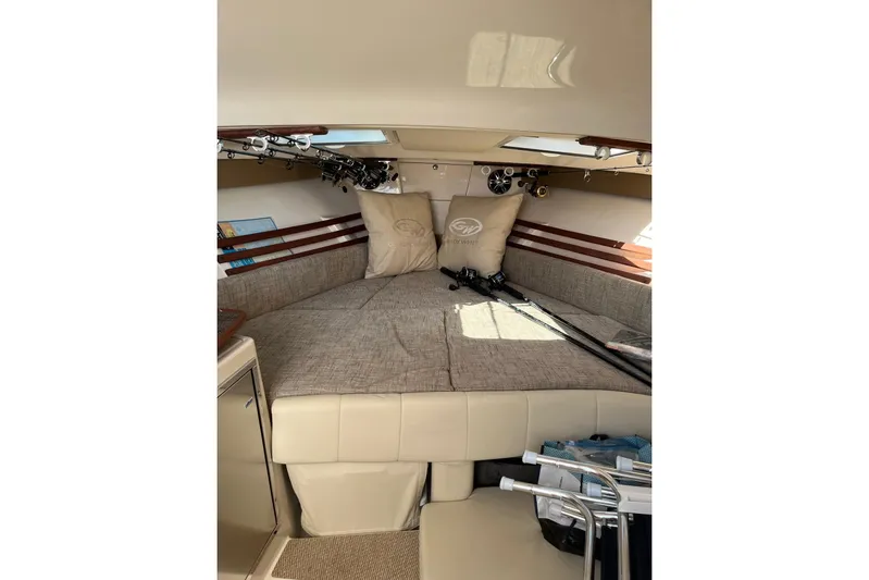Between Wakes Yacht Photos Pics 2020 Grady-White Express 330 cabin interior with fishing rods and cushions.