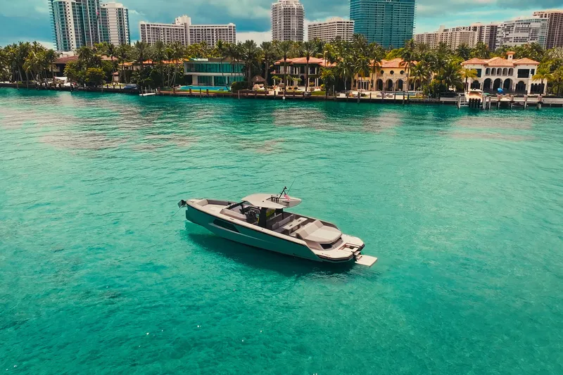 Mako Yacht Photos Pics 2024 Maori 46ft yacht on turquoise water with city skyline backdrop.