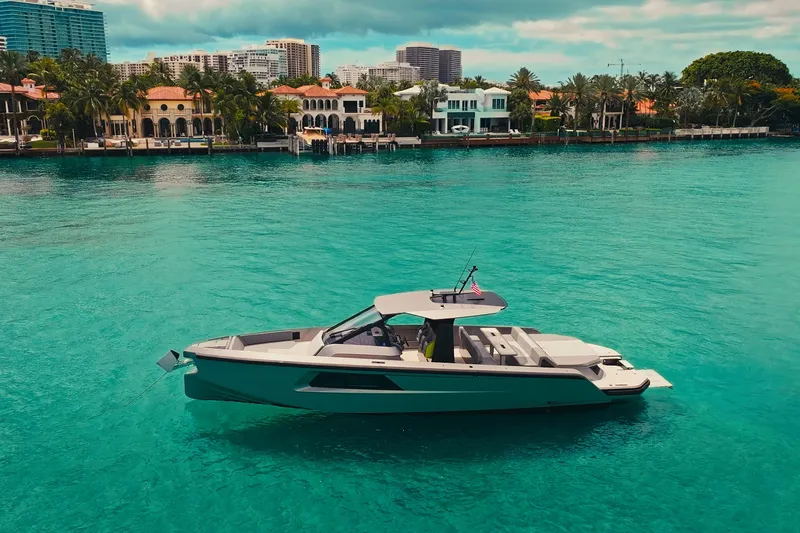 Mako Yacht Photos Pics 2024 Maori 46ft yacht on turquoise water near luxury waterfront homes.