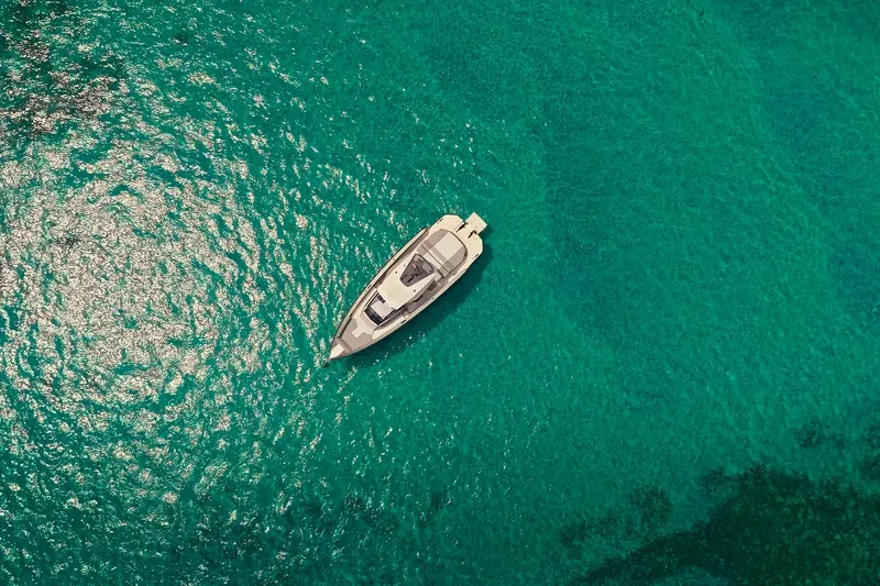 Mako Yacht Photos Pics Aerial view of 2024 Maori 46ft yacht on clear turquoise water.