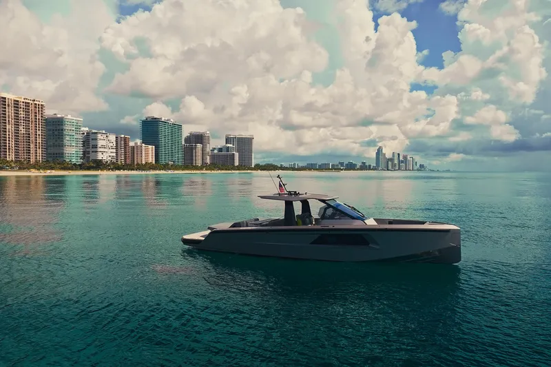 Mako Yacht Photos Pics 2024 Maori 46ft yacht cruising near city skyline under cloudy sky.