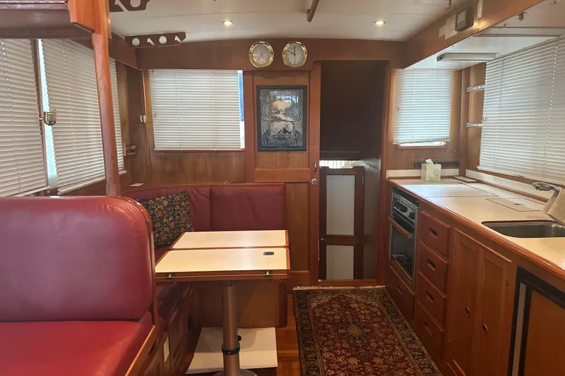 Phoenix Yacht Photos Pics Interior of 2000 Island Gypsy 36 yacht with wood finish and red seating.