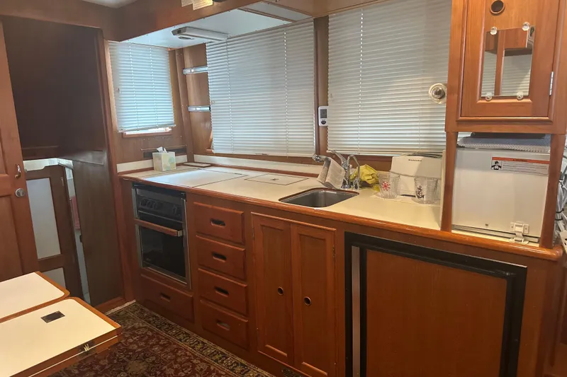 Phoenix Yacht Photos Pics Interior of 2000 Island Gypsy 36 yacht kitchen with wood cabinetry and appliances.