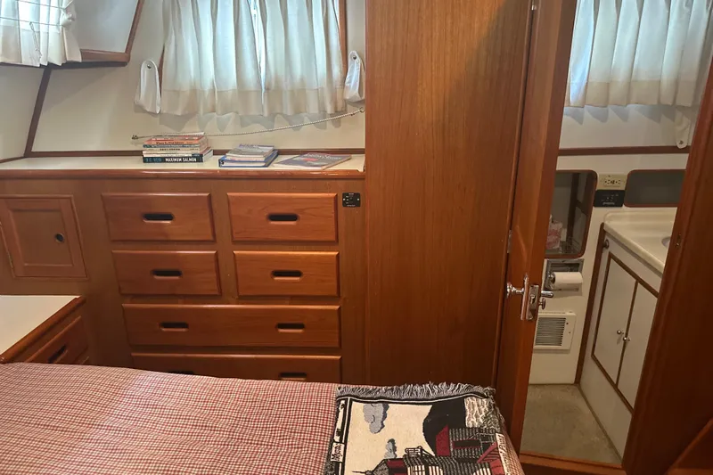 Phoenix Yacht Photos Pics Cozy cabin interior of 2000 Island Gypsy 36 with wooden drawers and books.