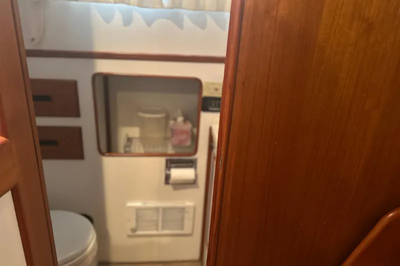 Phoenix Yacht Photos Pics Bathroom interior of a 2000 Island Gypsy 36 boat with wooden accents.