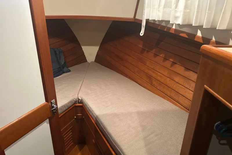 Phoenix Yacht Photos Pics Cozy cabin interior of 2000 Island Gypsy 36 with wooden paneling and cushioned berth.