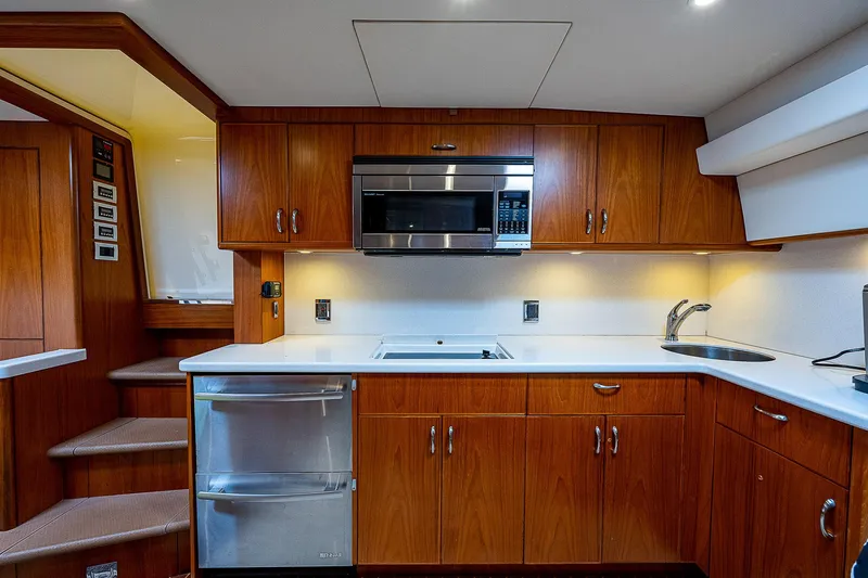 Wanted Yacht Photos Pics Luxurious 2012 Cabo 44 HTX yacht kitchen with wood cabinetry and modern appliances.