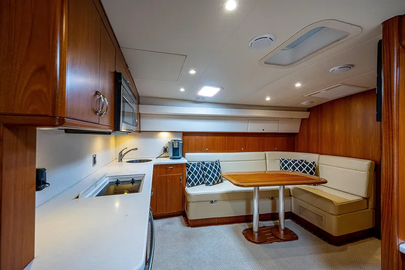 Wanted Yacht Photos Pics Luxurious interior of 2012 Cabo 44 HTX yacht with modern kitchen and cozy dining area.