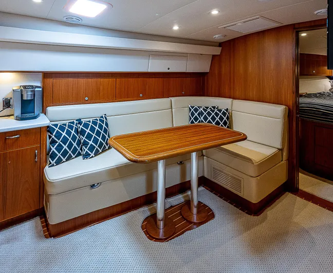 Wanted Yacht Photos Pics Luxurious interior of 2012 Cabo 44 HTX yacht with cozy seating and wooden table.