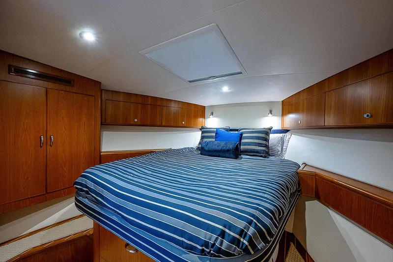 Wanted Yacht Photos Pics Luxurious cabin interior of 2012 Cabo 44 HTX yacht with striped bedding.