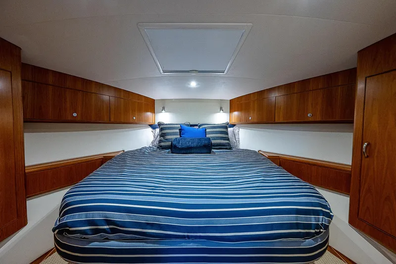 Wanted Yacht Photos Pics Luxurious cabin interior of 2012 Cabo 44 HTX yacht with striped bedding.