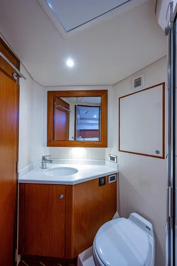 Wanted Yacht Photos Pics Luxurious bathroom interior of 2012 Cabo 44 HTX yacht with modern fixtures and wooden cabinetry.
