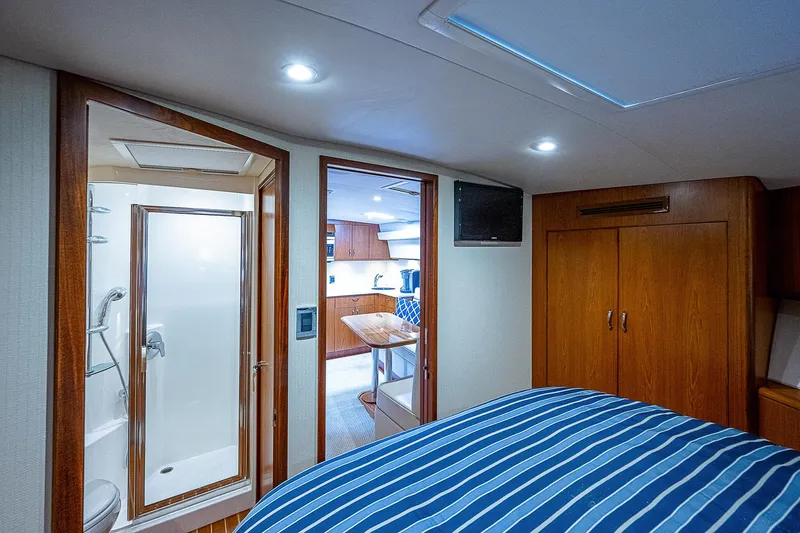 Wanted Yacht Photos Pics Interior of 2012 Cabo 44 HTX yacht with bedroom, bathroom, and wooden cabinetry.