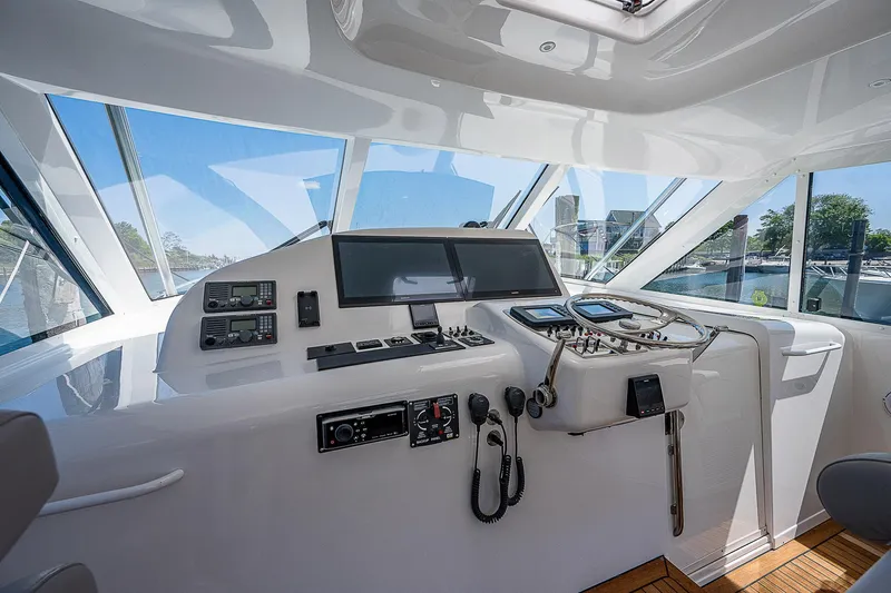 Wanted Yacht Photos Pics Helm of 2012 Cabo 44 HTX yacht with modern navigation equipment and panoramic windows.