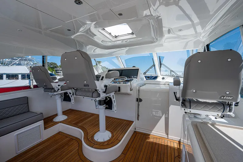 Wanted Yacht Photos Pics Interior of 2012 Cabo 44 HTX yacht with helm chairs and wooden flooring.