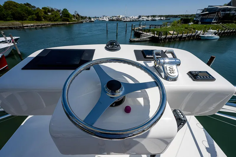 Wanted Yacht Photos Pics Steering wheel of 2012 Cabo 44 HTX yacht with marina view.