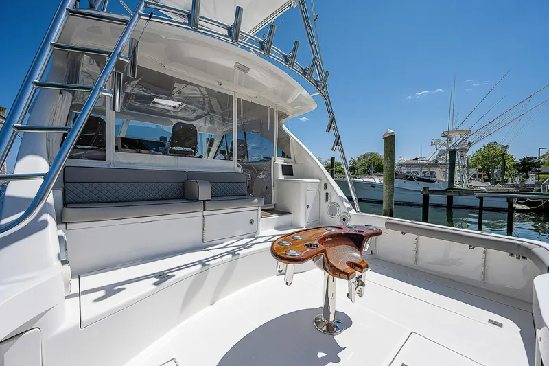 Wanted Yacht Photos Pics 2012 Cabo 44 HTX yacht cockpit with seating and fishing chair, docked under clear blue sky.