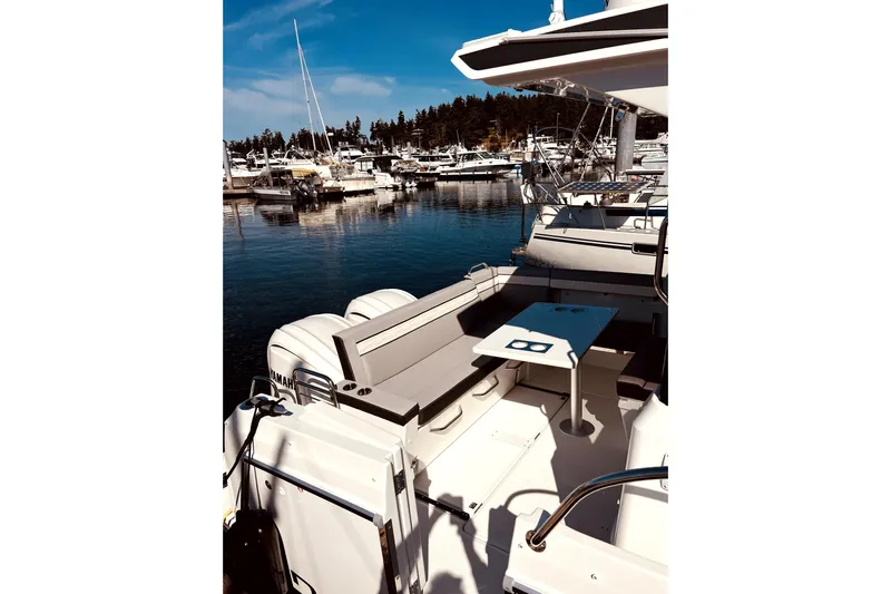 "halo" Yacht Photos Pics 2024 Jeanneau 8.95 boat docked in marina, featuring spacious seating and table.