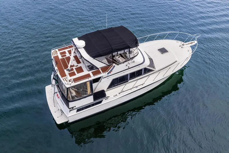 The Aquaholic Yacht Photos Pics 1988 Marine Trader Trawler on calm water, aerial view.