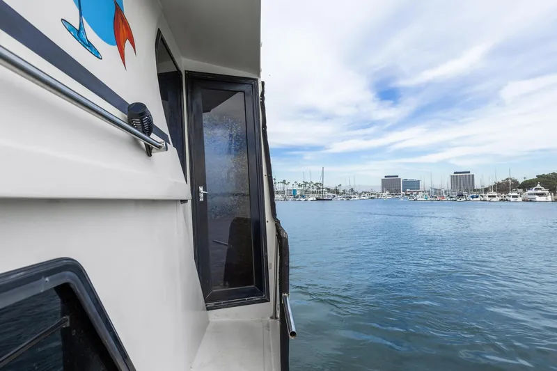 The Aquaholic Yacht Photos Pics 1988 Marine Trader Trawler docked at marina with cityscape in background.