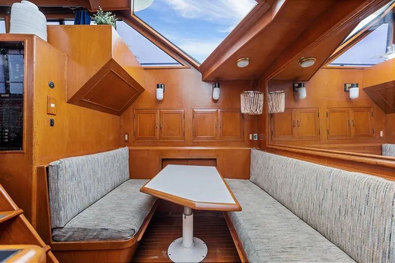 The Aquaholic Yacht Photos Pics 1988 Marine Trader Trawler interior with wood paneling and cozy seating area.