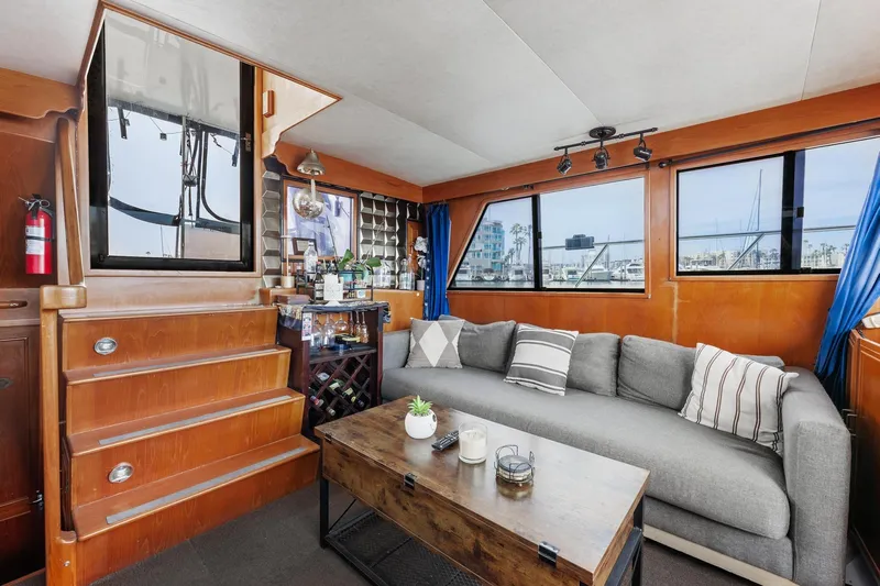 The Aquaholic Yacht Photos Pics Interior of 1988 Marine Trader Trawler with cozy seating, wooden accents, and nautical decor.