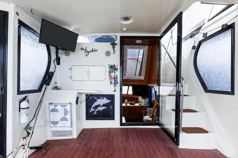 The Aquaholic Yacht Photos Pics 1988 Marine Trader Trawler interior with modern decor, TV, and nautical accents.