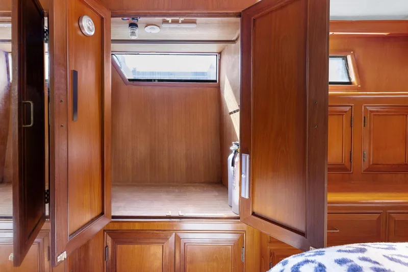 The Aquaholic Yacht Photos Pics 1988 Marine Trader Trawler interior with wooden cabinetry and storage space.