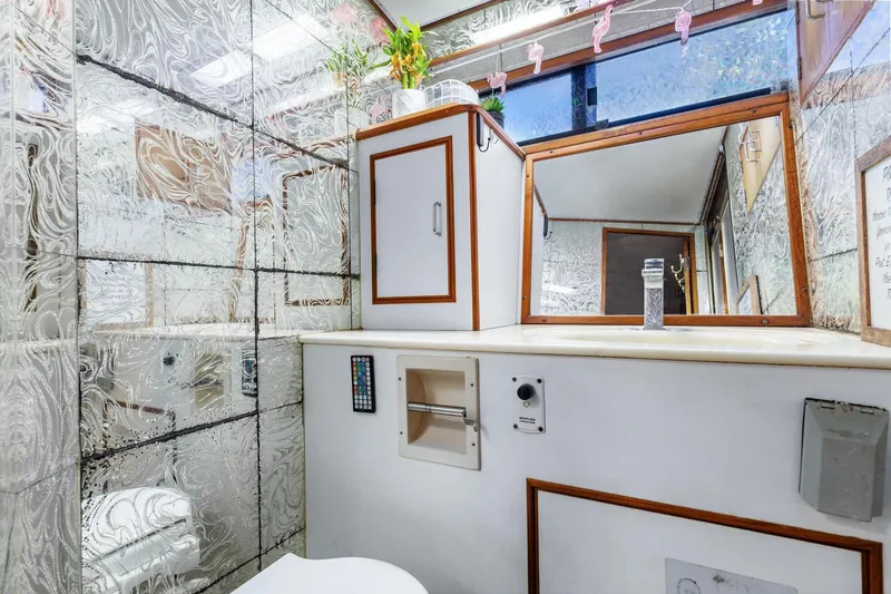 The Aquaholic Yacht Photos Pics 1988 Marine Trader Trawler bathroom with decorative glass walls and modern fixtures.