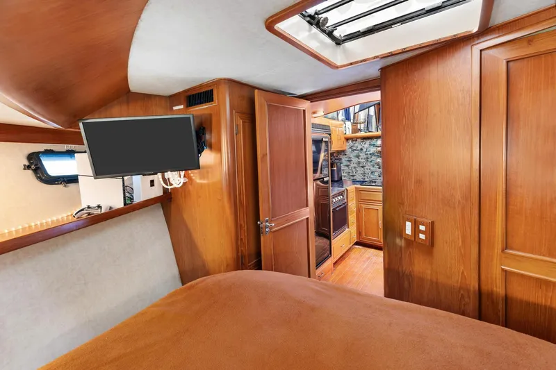 The Aquaholic Yacht Photos Pics 1988 Marine Trader Trawler interior with wood paneling, TV, and kitchen view.