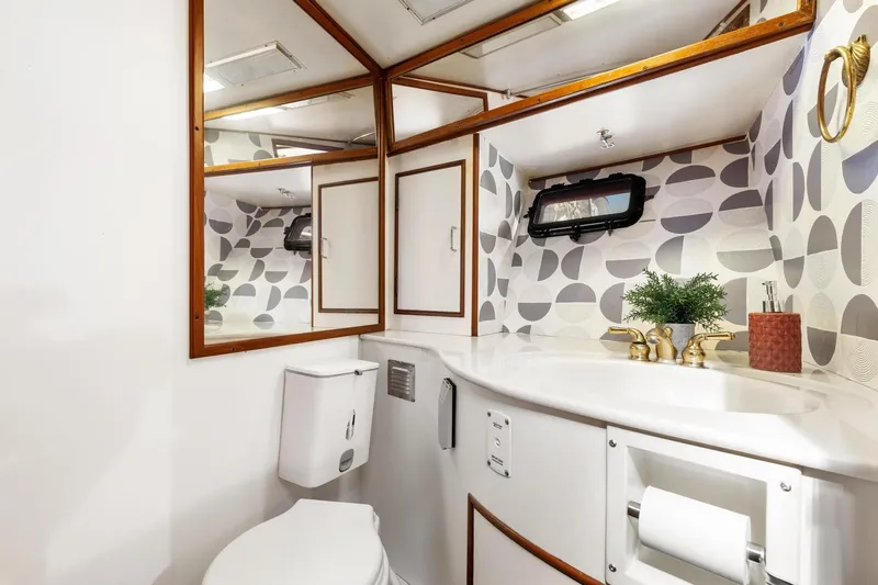 The Aquaholic Yacht Photos Pics Elegant 1988 Marine Trader Trawler bathroom with modern fixtures and geometric wallpaper.