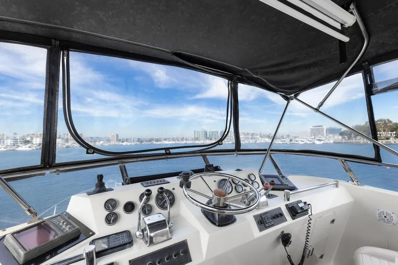 The Aquaholic Yacht Photos Pics 1988 Marine Trader Trawler helm with ocean view, featuring navigation instruments and steering wheel.
