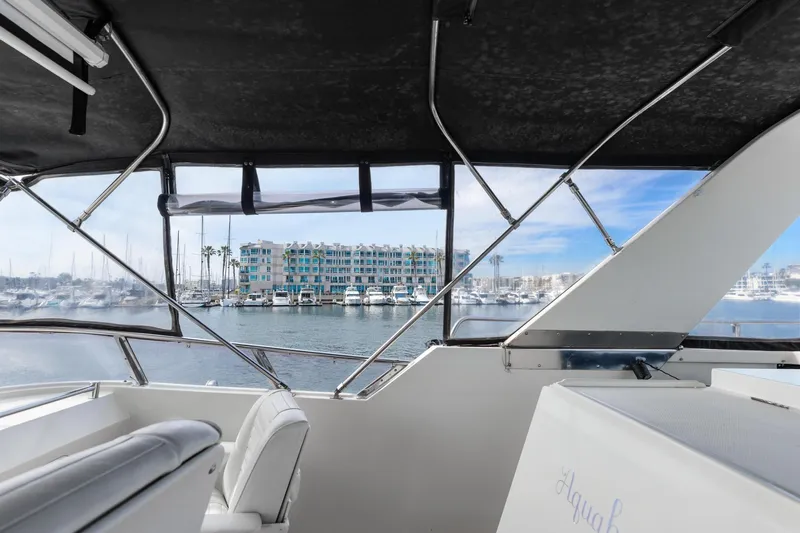 The Aquaholic Yacht Photos Pics 1988 Marine Trader Trawler interior view overlooking marina and waterfront buildings.