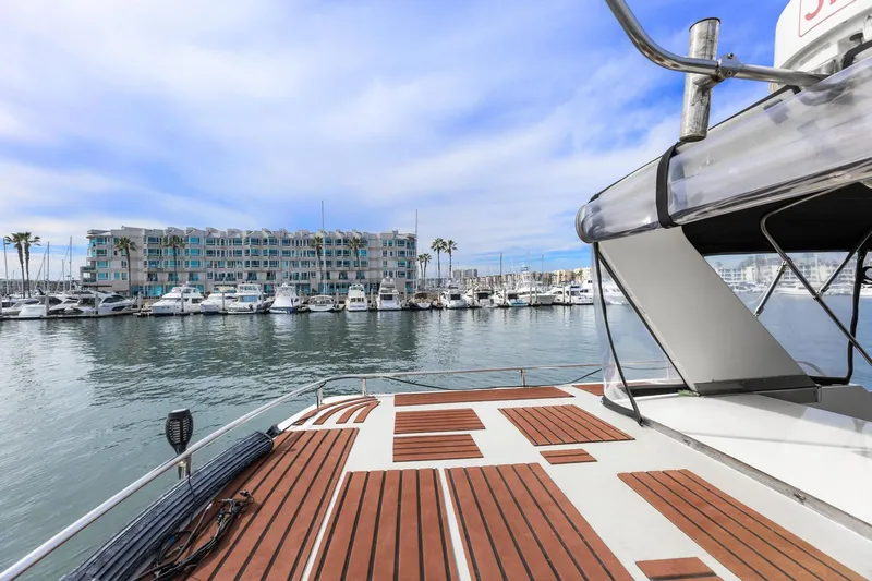 The Aquaholic Yacht Photos Pics 1988 Marine Trader Trawler docked at marina with waterfront view and blue sky.