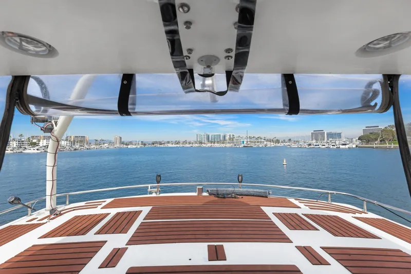The Aquaholic Yacht Photos Pics 1988 Marine Trader Trawler deck view overlooking marina and city skyline.