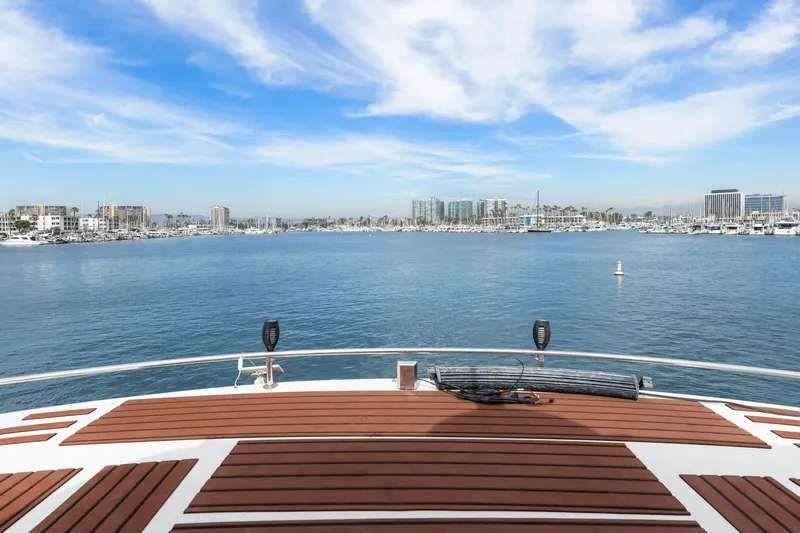The Aquaholic Yacht Photos Pics 1988 Marine Trader Trawler deck overlooking marina with clear blue sky and cityscape.