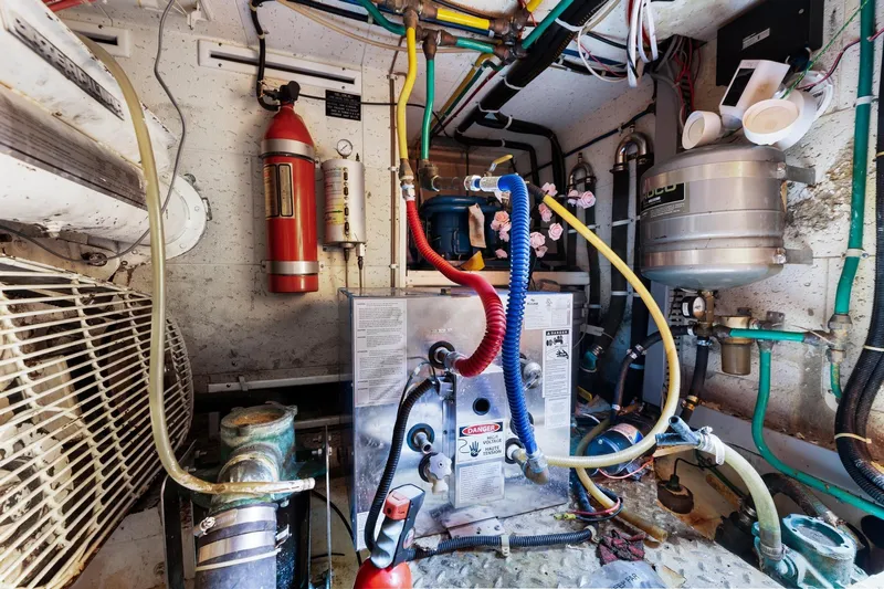 The Aquaholic Yacht Photos Pics Engine room of a 1988 Marine Trader Trawler with various mechanical components and pipes.