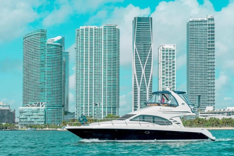  Yacht Photos Pics 2005 Sea Ray 420 Sedan Bridge yacht cruising near modern city skyline.