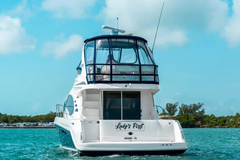  Yacht Photos Pics 2005 Sea Ray 420 Sedan Bridge yacht on clear blue water, rear view.