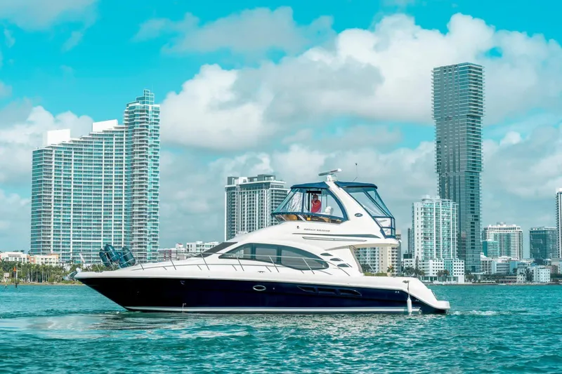  Yacht Photos Pics 2005 Sea Ray 420 Sedan Bridge yacht cruising near city skyline.