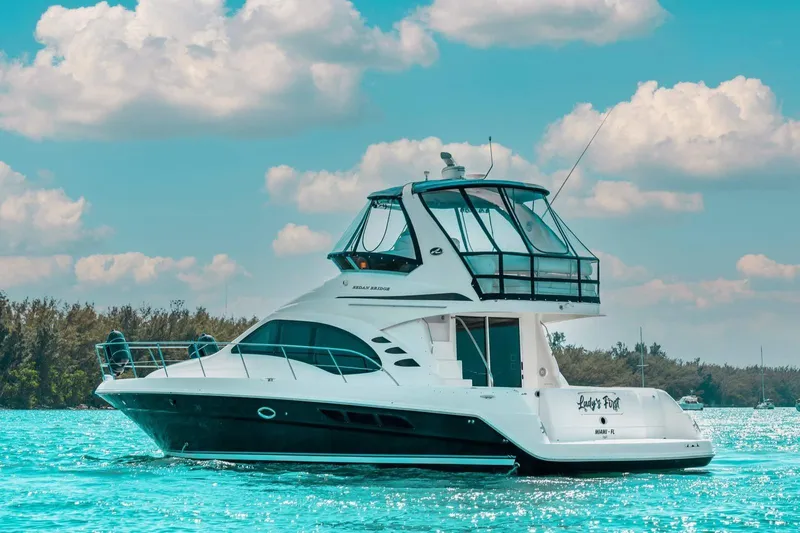  Yacht Photos Pics 2005 Sea Ray 420 Sedan Bridge yacht on clear blue water under a partly cloudy sky.