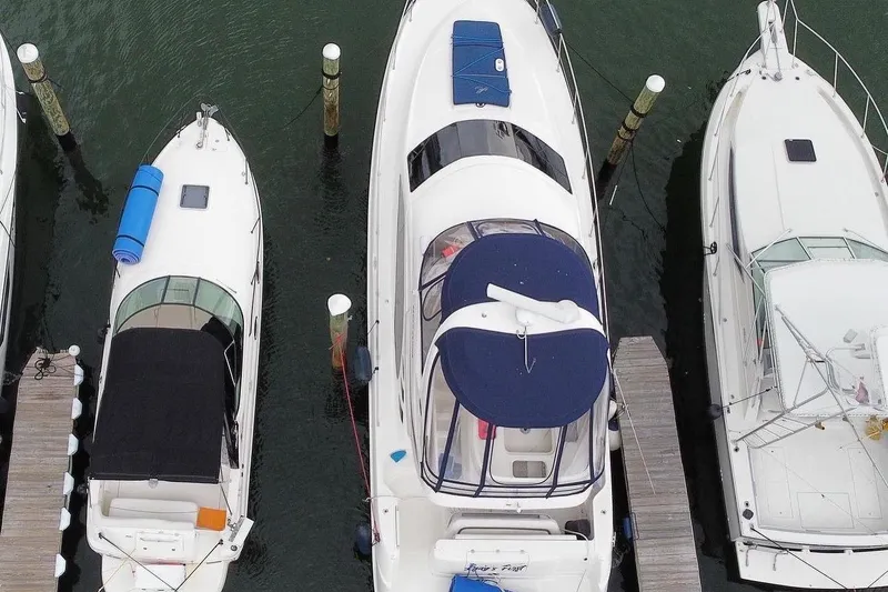  Yacht Photos Pics Aerial view of a 2005 Sea Ray 420 Sedan Bridge yacht docked between two boats.