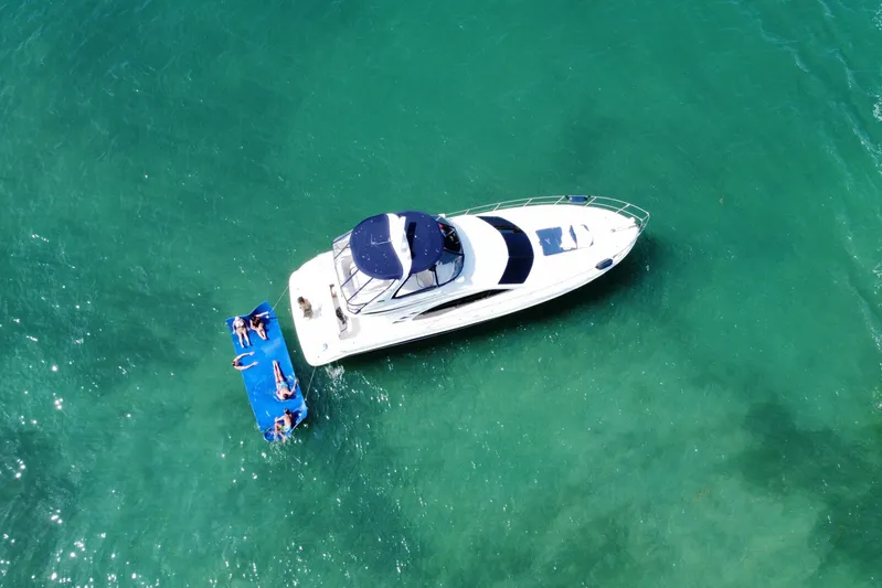  Yacht Photos Pics Aerial view of 2005 Sea Ray 420 Sedan Bridge yacht with people relaxing on a floating mat.