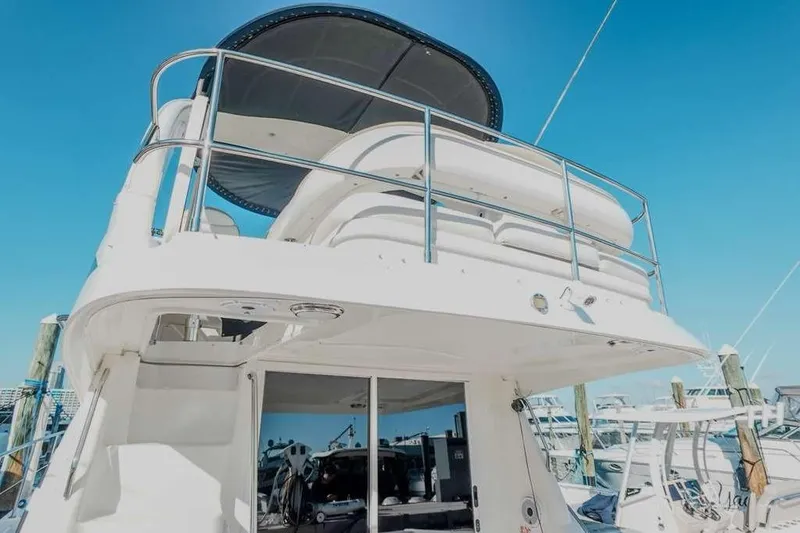  Yacht Photos Pics 2005 Sea Ray 420 Sedan Bridge yacht docked under clear blue sky.