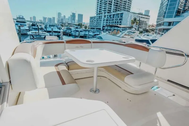  Yacht Photos Pics 2005 Sea Ray 420 Sedan Bridge yacht interior with seating and table, docked in marina.