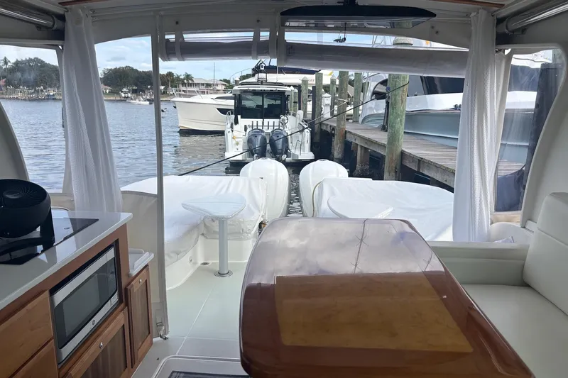 Fifth Child Yacht Photos Pics Interior view of 2019 Back Cove 34O yacht docked at marina, featuring kitchen and seating area.