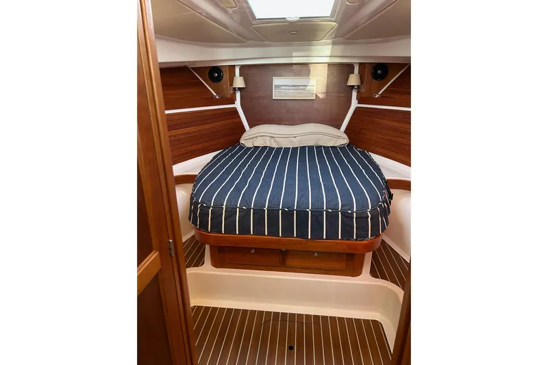 Fifth Child Yacht Photos Pics 2019 Back Cove 34O cabin with striped bedding and wooden interior.