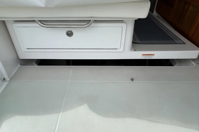 Fifth Child Yacht Photos Pics 2019 Back Cove 34O interior storage compartment with white cushioned seating.